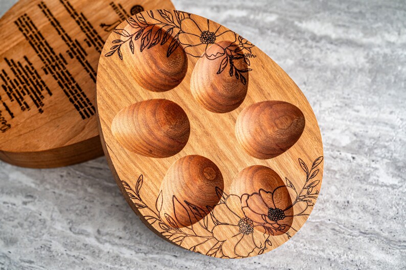 Peut inclure: Un porte-&oelig;ufs en bois avec cinq compartiments individuels pour contenir des &oelig;ufs. Le porte-&oelig;ufs est d&eacute;cor&eacute; d'un motif floral et a une finition en bois naturel.