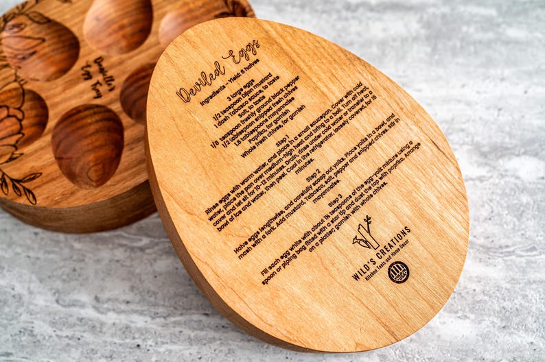 Peut inclure: Plateau de service en bois avec six cavit&eacute;s individuelles en forme d'&oelig;uf et une recette d'&oelig;ufs &agrave; la diable grav&eacute;e sur la surface. La recette comprend les ingr&eacute;dients et les instructions pour pr&eacute;parer des &oelig;ufs &agrave; la diable. Le plateau est &eacute;tiquet&eacute; "Wild's Creations".