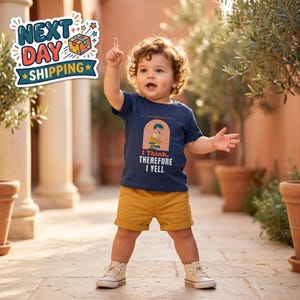 May include: A navy blue t-shirt featuring a graphic of a child sitting on a stool with the text "TINY PHILOSOPHER" and "I THINK, THEREFORE I YELL" paired with mustard yellow shorts and white sneakers. The shirt has a crew neckline.