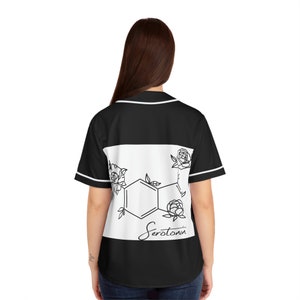 May include: Black baseball jersey with white trim and a white panel on the back. The panel displays a black and white graphic of the serotonin molecule, roses, and the word "Serotonin".