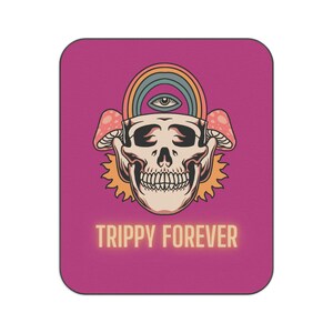 Puede incluir: Alfombrilla de ratón rectangular magenta con un diseño de calavera, arcoíris, ojo y setas. Las palabras "TRIPPY FOREVER" están impresas en una fuente brillante en la parte inferior.
