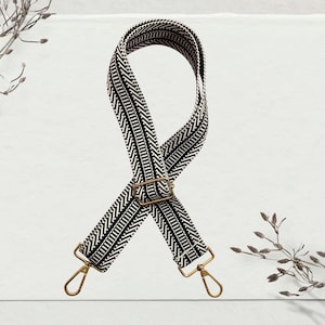 May include: Black and white chevron patterned adjustable strap with gold metal clasps.