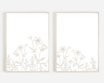 Puede incluir: Dos impresiones enmarcadas con un dibujo lineal minimalista de un ramo de flores en beige sobre un fondo blanco.