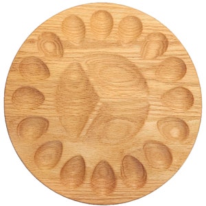 May include: A round wooden serving tray with 18 individual indentations, perfect for serving appetizers or snacks.