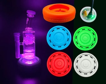May include: A set of six silicone glow-in-the-dark discs in various colors, including blue, green, red, and white. The discs have a raised center and a textured outer edge. The text "GlowGuard1" is printed on the orange disc.
