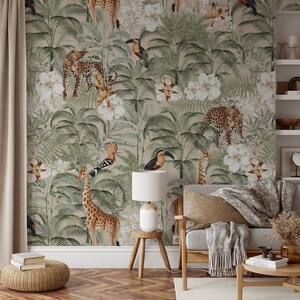 May include: A beige wallpaper with a jungle theme featuring a giraffe, leopards, toucans, and exotic flowers. The wallpaper is displayed in a living room setting with a couch, a lamp, and a side table.