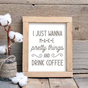 May include: A wooden framed sign with the text "I JUST WANNA M-A-K-E pretty things AND DRINK COFFEE" in a brown font on a white background.