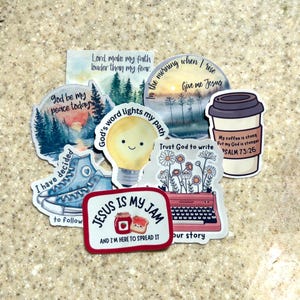 May include: A selection of vibrant stickers featuring motivational quotes and illustrations. Designs include a lightbulb, coffee cup, typewriter, and trainers. Text includes "Jesus is my Jam" and "God's word lights my path."