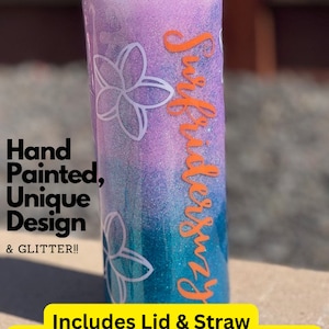 May include: A 20 ounce skinny tumbler with a purple and blue glitter design. The tumbler has a white flower design and the text "Surfiubersuzy" in orange. It includes a lid and straw.