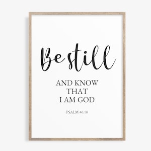 Op de afbeelding: Een zwart-witte printbare wandkunstprint met de tekst "Be still and know that I am God" en de bijbelverwijzing "Psalm 46:10".