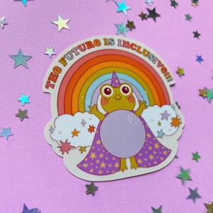 May include: A sticker with a rainbow and a frog wearing a wizard hat and a cape with stars. The text on the sticker says "The Future is Inclusive!!"