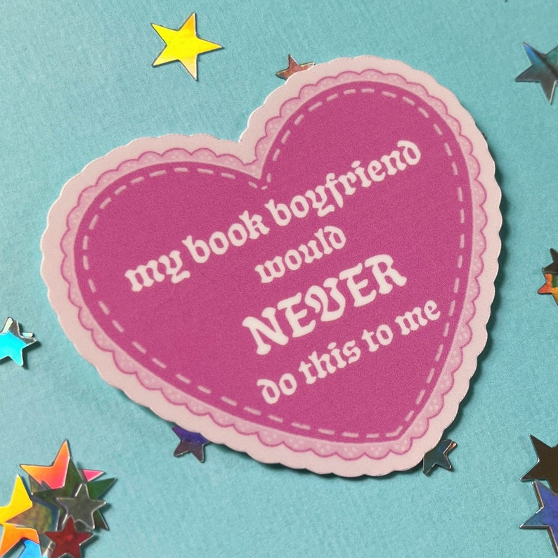 May include: Pink heart-shaped sticker with a white border and white text that reads "my book boyfriend would NEVER do this to me".