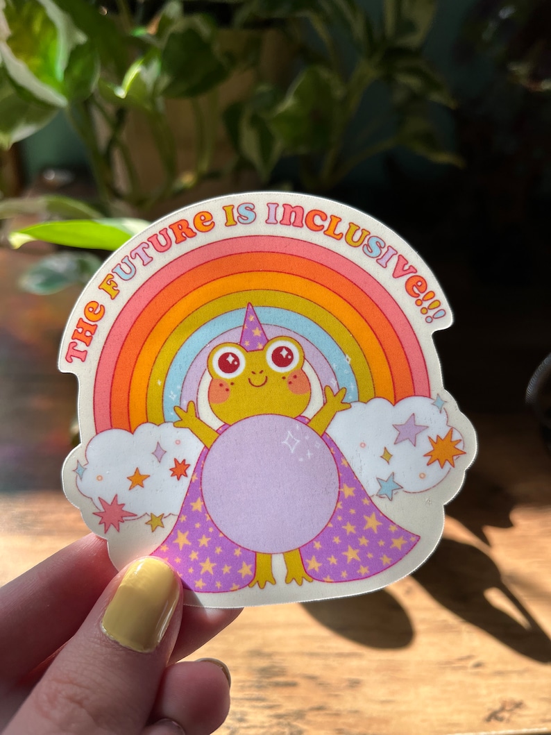 May include: A sticker with a rainbow, a frog wearing a purple cape with stars, and the text "The Future is Inclusive!!!"