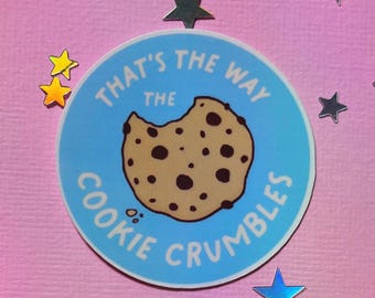 May include: A blue and white round sticker with the text "That's the way the cookie crumbles" and a cartoon image of a chocolate chip cookie.