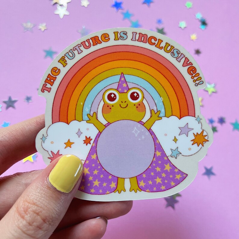 May include: A sticker featuring a cartoon frog wearing a purple cape and a wizard hat, standing in front of a rainbow with the text "The Future is Inclusive!!"