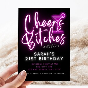 Op de afbeelding: Een zwart-witte uitnodiging met roze neontekst die "Cheers Bitches" zegt met een cocktailglasicoon. De uitnodiging is voor Sarah's 21e verjaardag. Het feest is op zaterdag 3 mei om 19:00 uur in The City Pub, 123 Any Street, Any City. RSVP naar Meg v&oacute;&oacute;r 5 april op 123-456-789.