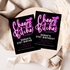 Op de afbeelding: Een zwart-witte uitnodiging met roze neontekst die "Cheers Bitches" en een cocktailglas-icoon toont. De uitnodiging is voor Sarah's 21e verjaardagsparty. Het feest is op zaterdag 3 mei om 19:00 uur in The City Pub, 125 Any Street, Any City. RSVP aan Meg v&oacute;&oacute;r 5 april op 123-456-789.