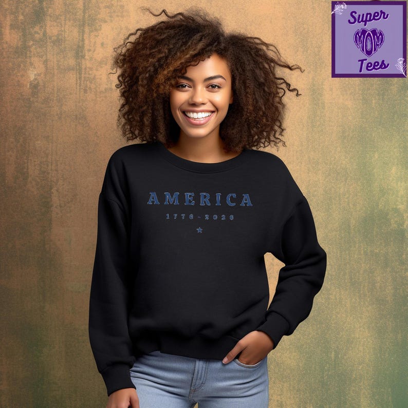 Puede incluir: Sudadera negra con la palabra "AMERICA" en letras azules, los a&ntilde;os "1776-2020" y una estrella. La sudadera de cuello redondo tiene mangas largas.