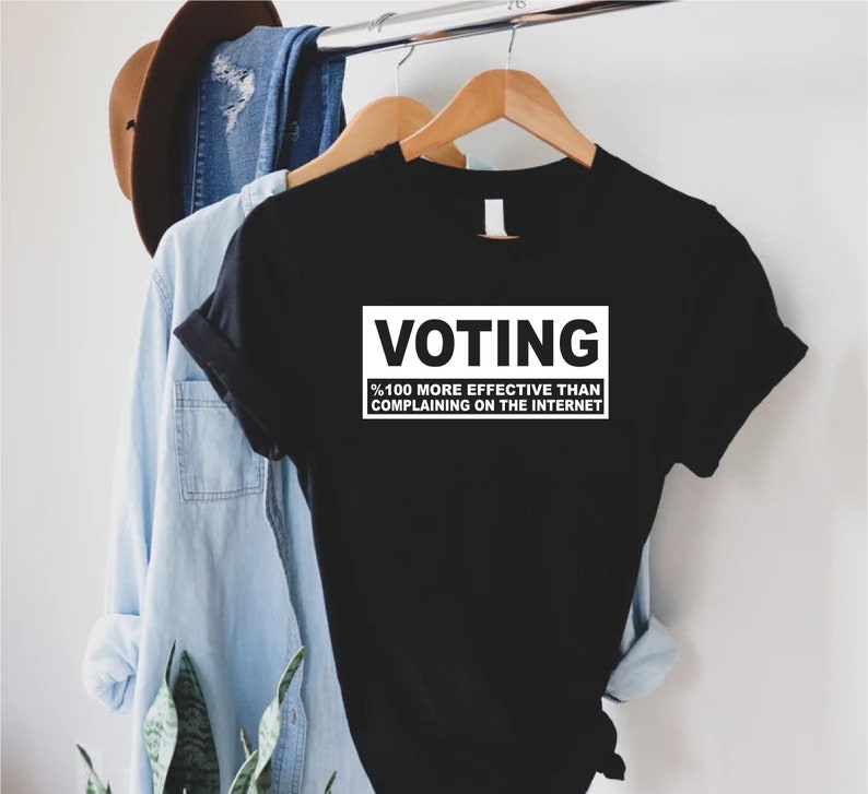 May include: Black t-shirt with white text that reads "Voting %100 more effective than complaining on the internet."
