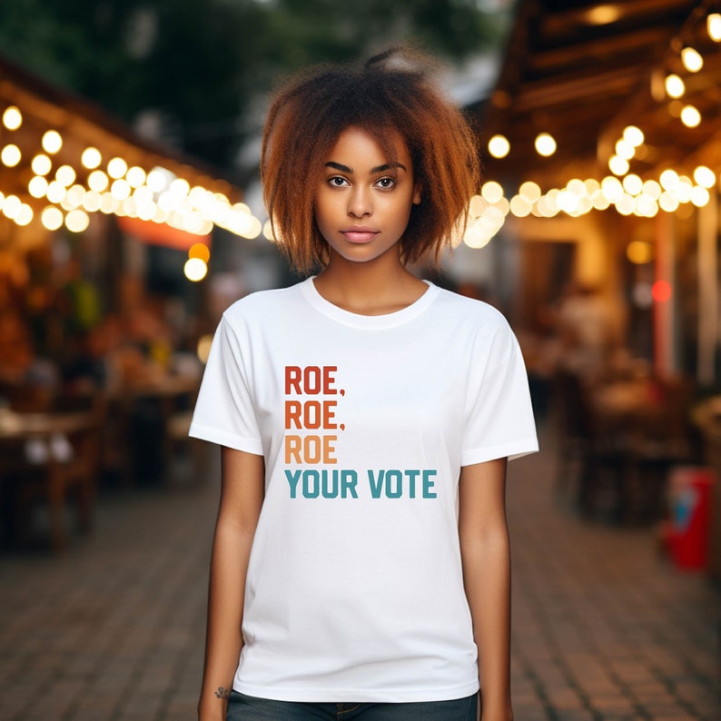 a woman with a white t - shirt that says rose rose, your vote