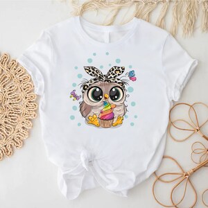 a white shirt with an owl with a bow on it