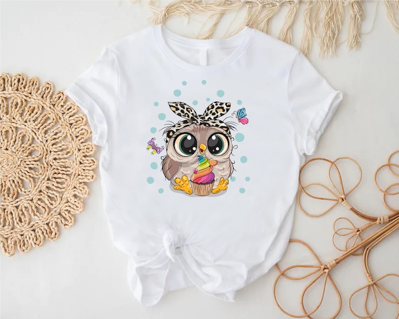 a white shirt with an owl with a bow on it