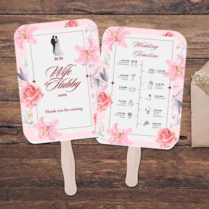 May include: Two pink wedding fans with floral designs. One fan says "We Do Wife + Hubby" and the other fan has a wedding timeline with times and icons.