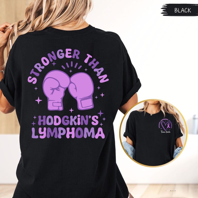 May include: Black t-shirt with a purple graphic on the back that says "STRONGER THAN HODGKIN'S LYMPHOMA" with boxing gloves. A smaller image on the side shows a purple ribbon and the words "Team Linda".