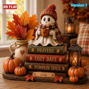 Può includere: Una decorazione da tavolo con una statuetta di fantasma che indossa un berretto di lana rosso e una sciarpa a quadri, mentre tiene in mano una tazza. Poggia su tre libri intitolati PRAYERS, COZY DAYS e PUMPKIN SPICE, con una targhetta con il nome Emily, zucche e un vaso di foglie autunnali.