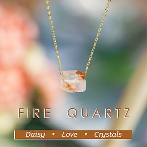 Op de afbeelding: Een gouden ketting met een heldere, gefacetteerde, roodbruine vuurquartz hanger. De hanger heeft een rechthoekige vorm. De tekst "FIRE QUARTZ" staat onder de hanger, en de tekst "Daisy • Love • Crystals" staat eronder.