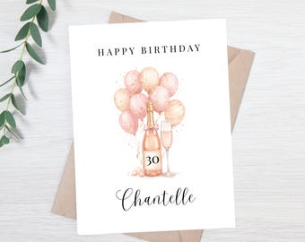 May include: A birthday card with the words "Happy Birthday" at the top. The card features a watercolor illustration of pink balloons, a champagne bottle, a champagne flute, and the number 30. The name "Chantelle" is written at the bottom.