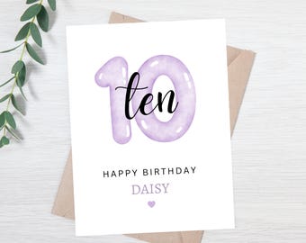 May include: Purple and white birthday card with the number 10 in the shape of a balloon. The number 10 has the word "ten" written inside. The card says "Happy Birthday Daisy" with a small purple heart.