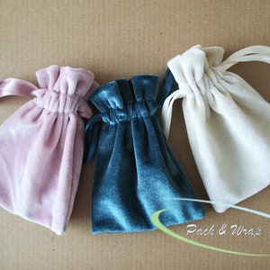 Puede incluir: Tres bolsitas de terciopelo con cordón de ajuste en rosa, azul verdoso y blanco. Las bolsitas están hechas de terciopelo suave y lujoso y tienen un cordón de ajuste de cinta de satén.