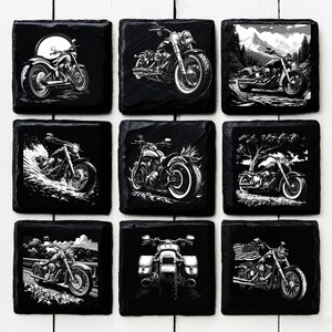 Może przedstawiać: Zestaw dziewięciu czarnych podkładek ze łupka z białymi ilustracjami motocykli. Każda podkładka ma inny wz&oacute;r, w tym motocykl w lesie, motocykl w wodzie i motocykl z amerykańską flagą.