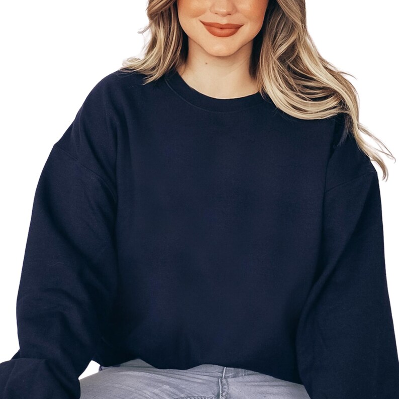 a woman wearing a black sweatshirt and jeans