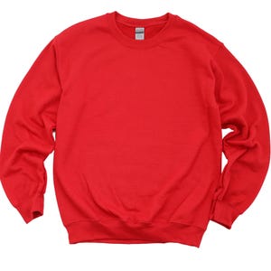 May include: A solid red crewneck sweatshirt. The long-sleeved top has a ribbed hem and cuffs, and a tag is visible at the back of the neck. The sweatshirt is made of a soft, comfortable material.