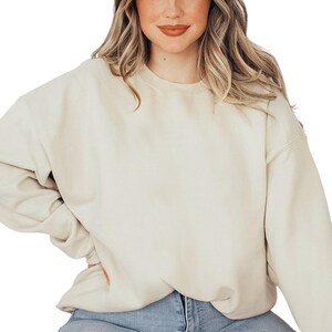 a woman wearing a white sweatshirt and jeans