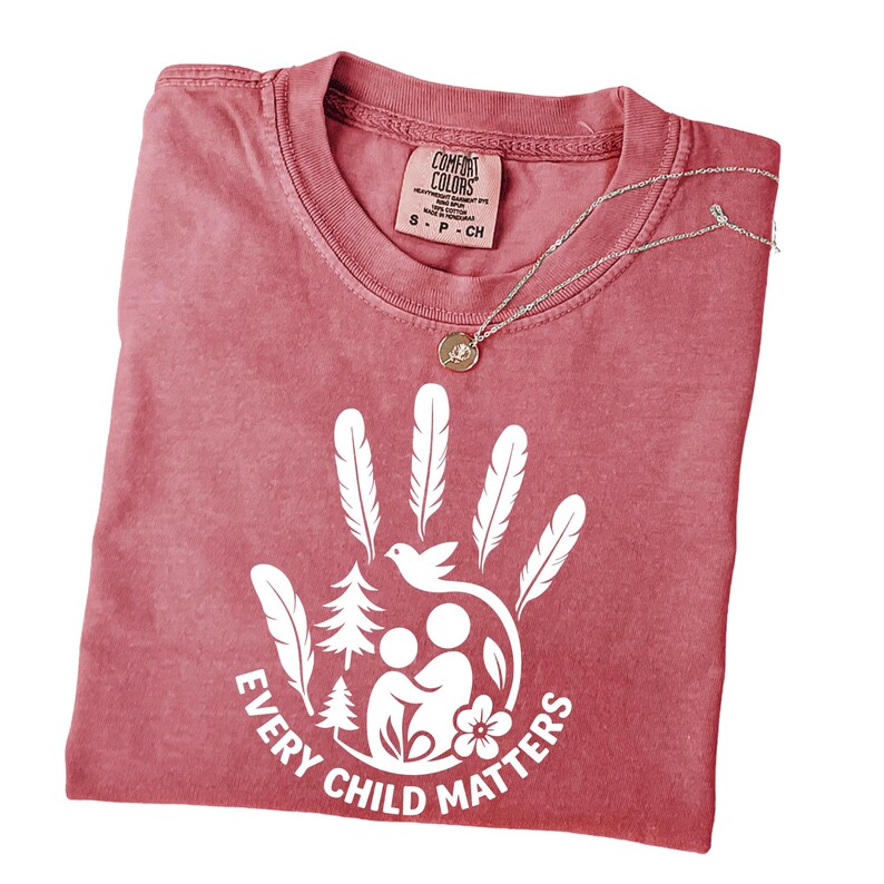 A red t-shirt with a white handprint design and the text "EVERY CHILD MATTERS" printed on it.