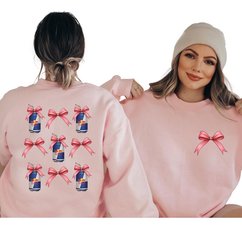 two women wearing pink sweaters with pink bows on the back.
