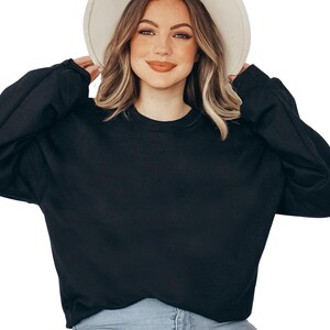 a woman wearing a black sweater and a white hat