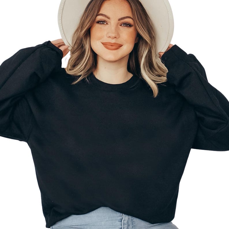 a woman wearing a black sweater and a white hat