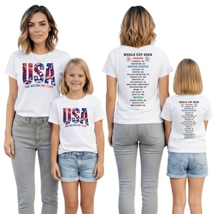 two women and two young girls wearing white t-shirts with the text "USA ONE NATION ONE TEAM" printed on them.