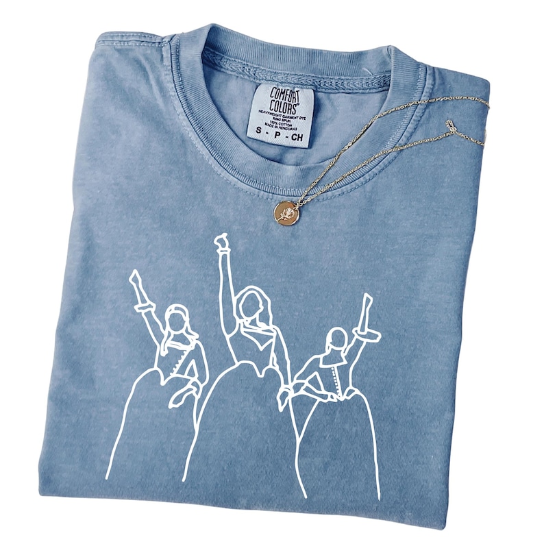 a blue t - shirt with a picture of a group of people on it