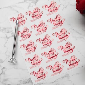 May include: A sheet of white paper with 12 pink and red stickers that say "Pretty things inside".