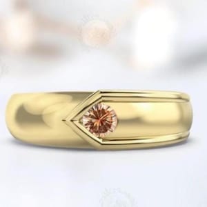 May include: A gold band ring with a single, round, light brown gemstone set in a triangular shape.