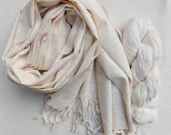 May include: A cream-colored silk scarf with a fringe border and a skein of cream-colored silk yarn.