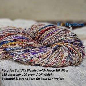 May include: A skein of recycled sari silk yarn blended with peace silk fibre. The yarn is a mix of white, red, blue, yellow, and purple. The yarn is 135 yards per 100 grams and is DK weight. The yarn is described as beautiful and strong.