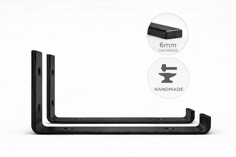 May include: Two black, L-shaped metal shelf brackets. The brackets are handmade and have a 6mm thickness. The brackets are designed to be mounted on a wall to support shelves. The brackets are shown on a white background.