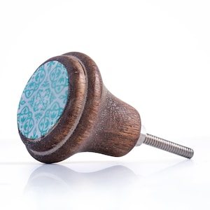 May include: A wooden cabinet knob with a decorative turquoise and white patterned face. The knob is a dark brown colour and has a threaded metal screw for installation. The design is a classic style.