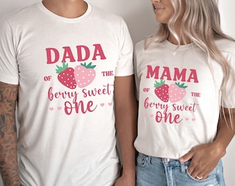 May include: Two white t-shirts with a strawberry graphic and the text "Dada of the berry sweet one" and "Mama of the berry sweet one".